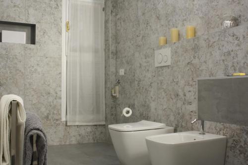een badkamer met een wit toilet en een wastafel bij Appartamento Biba in Bologna