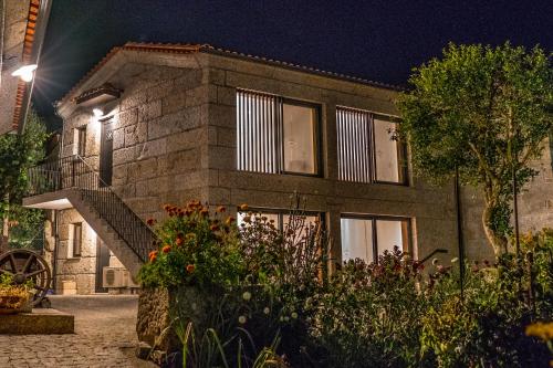 a brick house with a staircase in front of it at night at Casa do Vale in Fafe
