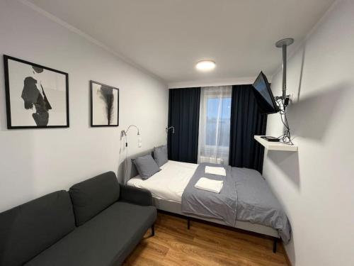 Habitación pequeña con cama y sofá en Komfortowe apartamenty w centrum Wrocławia, en Wroclaw