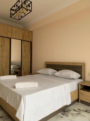 a bedroom with a large bed with white sheets and pillows at City Central Apartment in Yerevan