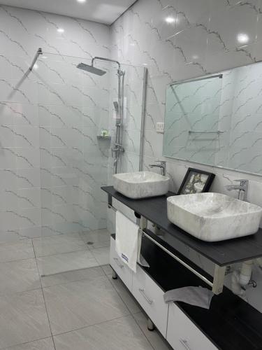 a bathroom with two sinks and a mirror at Meanwood Place Apartments in Lusaka