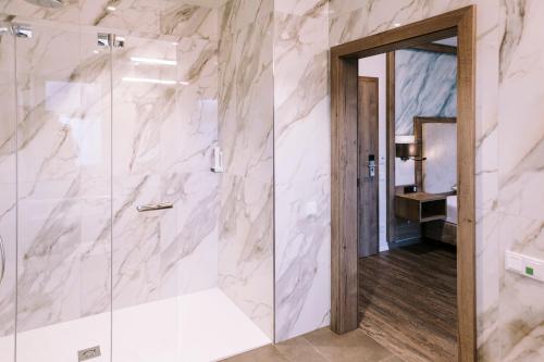 a bathroom with a shower with a glass door at Hotel Traunfall in Viecht