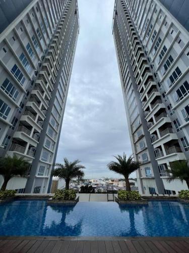 two tall buildings with a swimming pool between them at Podomoro City Deli Medan Tower Empire - Japandi Style - 2BR Family Suite 3 beds - 87m in Medan