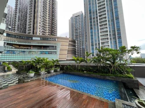 une piscine sur le toit d'un immeuble avec de grands bâtiments dans l'établissement Podomoro City Deli Medan Tower Empire - Japandi Style, à Medan