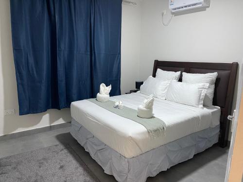 Un dormitorio con una cama con dos estatuas de gato. en Meanwood Place Apartments en Lusaka