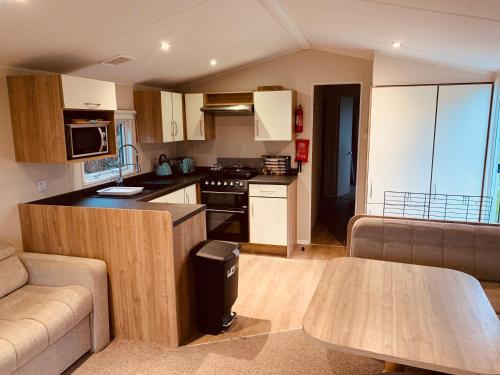 a kitchen and living room with a couch and a table at 69 Newquay bay resort Pet friendly in Newquay