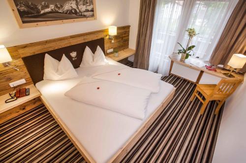 a bedroom with a bed with white pillows on it at Gasthof zum Wilden Kaiser in Scheffau am Wilden Kaiser