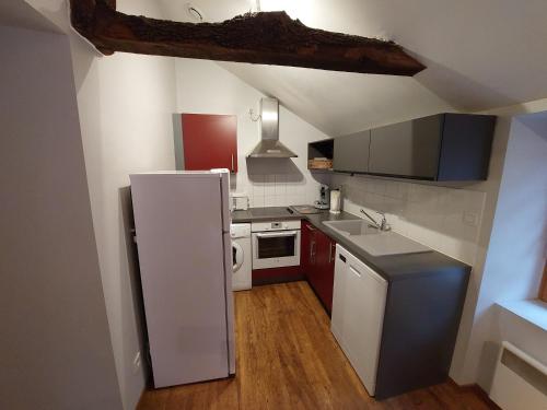 Elle comprend une petite cuisine équipée d'un réfrigérateur blanc et de placards. dans l'établissement Bel appartement duplex avec jardin pour 6 personnes, à Luz-Saint-Sauveur