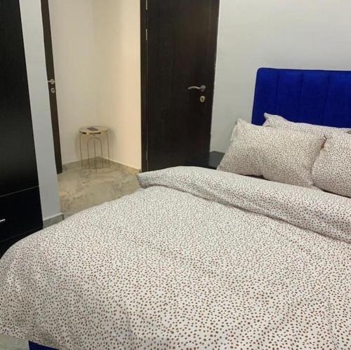 1 dormitorio con 1 cama grande y cabecero azul en Lovely 2 bedroom in osapa london, en Lekki