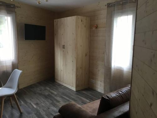 un salon avec un canapé et une télévision sur un mur dans l'établissement Les Améthystes, à Le Mont-Dore