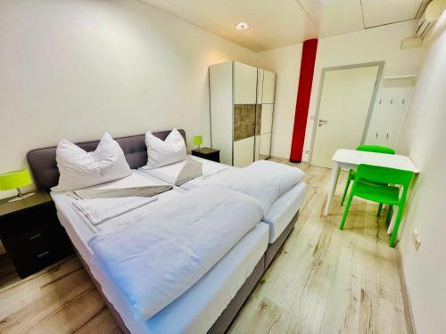 a large bed in a room with a green chair at Kobra Apartment für Gruppen perfekt geeignet in Spielberg