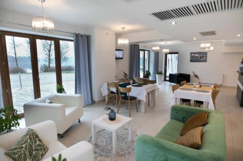 a living room with white furniture and a dining room at Rezydencja Margonin in Margonin