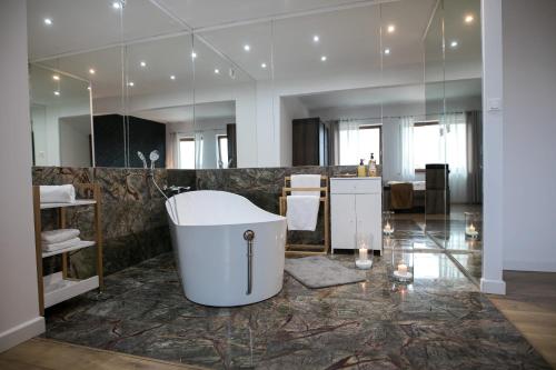 a bathroom with a bath tub and a mirror at Rezydencja Margonin in Margonin