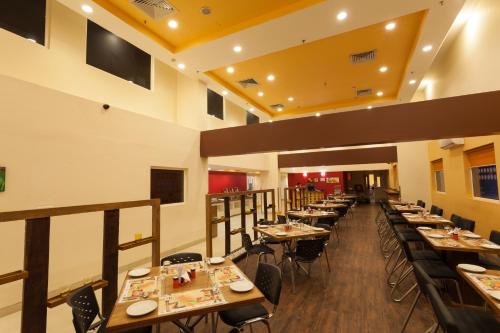 a dining room with tables and chairs in a restaurant at Ginger Ahmedabad Vastrapur in Ahmedabad