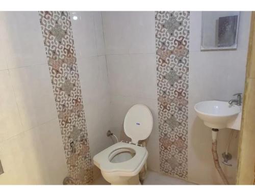 a bathroom with a toilet and a sink at Hotel Anand,Junagadh in Junagadh