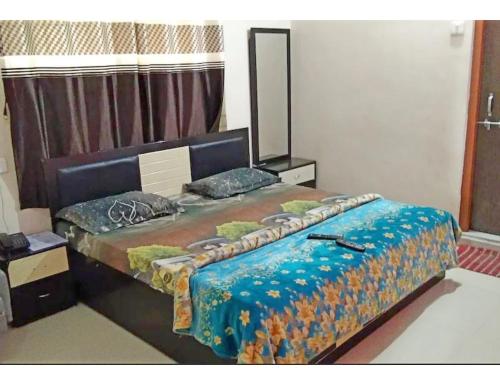 a bedroom with a large bed in a room at Hotel Anand,Junagadh in Junagadh