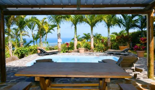 a patio with a table and chairs next to a pool at Fenetre sur Mer in Rodrigues Island