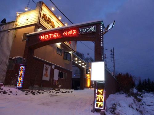 un cartello per un hotel nella neve di notte di Hotel Vegas (Adult Only) a Sapporo