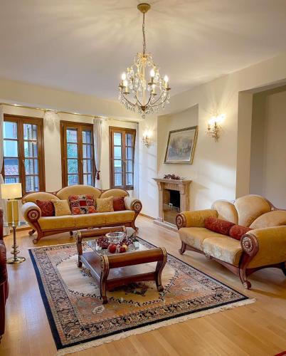 a living room with couches and a chandelier at Villa Voulgari in Ioannina