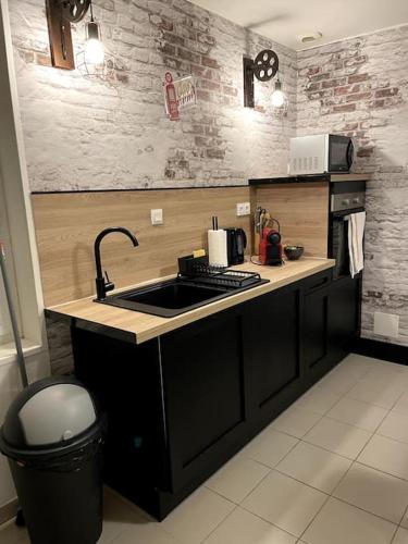 une cuisine avec un évier et un plan de travail dans l'établissement T2 Centre ville La Licorne 2, à Pont-Audemer