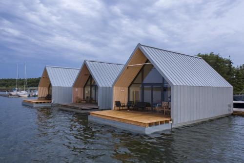 three houses on a dock in the water at Domy na Wodzie na Mazurach in Pisz