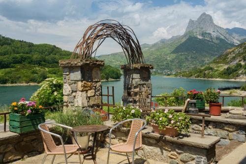 Hotel La Casueña في لانوزا: فناء مع طاولة وكراسي وإطلالة على البحيرة