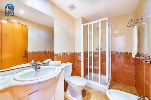 a bathroom with a toilet sink and a shower at Residencial Marcomar Casa Azahar in Alcossebre