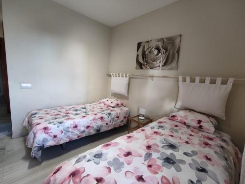 ein Schlafzimmer mit 2 Betten und einem Wandgemälde in der Unterkunft Flamingo Sol Home in Torremolinos