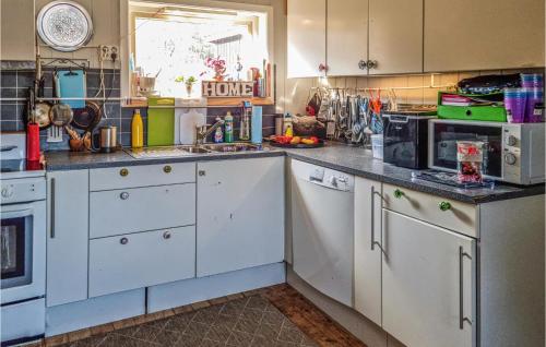 a kitchen with white cabinets and a sink at 2 Bedroom Pet Friendly Home In Kristiansand in Kristiansand
