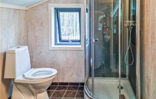 La salle de bains est pourvue de toilettes et d'une douche en verre. dans l'établissement 2 Bedroom Pet Friendly Home In Kristiansand, à Kristiansand