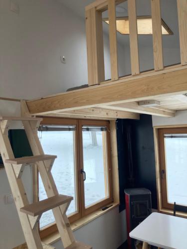 a loft bed in a room with a window at Tiny house in Mislinja
