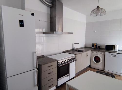 La cuisine est équipée d'un réfrigérateur blanc et d'un lave-vaisselle. dans l'établissement Casa Independiente Centro, à Águilas