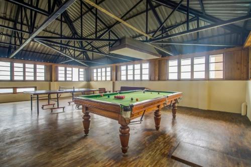 a room with a pool table and two tables at Summit Namnang Courtyard & Spa Near Mg Marg in Gangtok