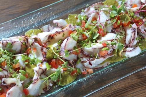 a dish of salad with meat and vegetables on a table at InterContinental Real Santo Domingo by IHG in Santo Domingo