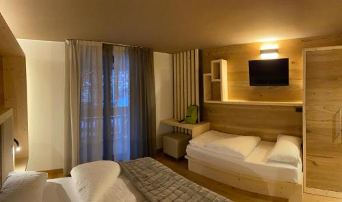 a hotel room with a bed and a television at Rauzi Hotel Garnì & apartments in Malè