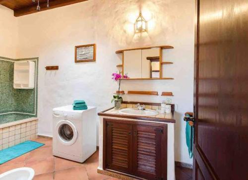 un bagno con lavatrice e lavandino di El Caserío de Güime Villa con Piscina Climatizada a San Bartolomé