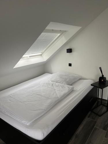 a white bed with a skylight in a bedroom at Haus Gabor in Mülheim an der Ruhr