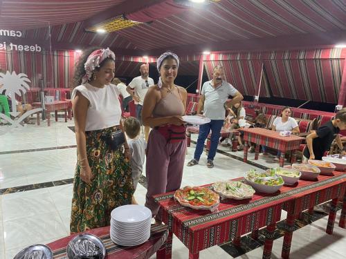 Deux femmes devant une table de nourriture dans l'établissement Blue Camel, à Wadi Rum