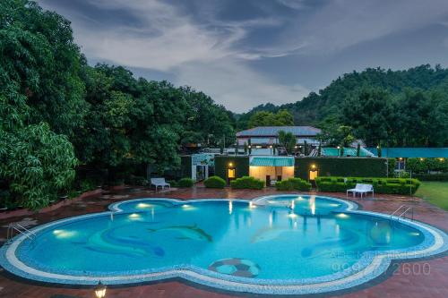 an overhead view of a swimming pool at night at Wood castle Spa & Resort in Rāmnagar
