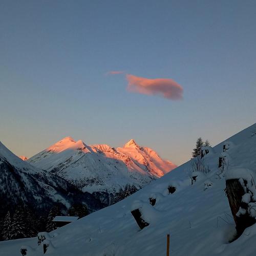 a snow covered mountain with the sun shining on it at Ebner Casa in Heiligenblut