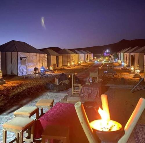un gruppo di tende nel deserto di notte di Merzouga Luxury Camp a Merzouga