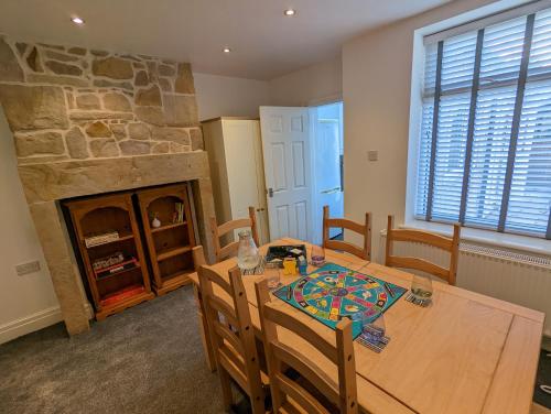 a dining room with a table and a stone fireplace at 3 Bed City Home - South Facing Patio - 4-5 Beds in Lancaster