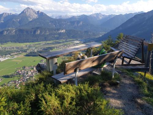 a wooden bench sitting on top of a mountain at Chalet Panorama Tirol in Hofen