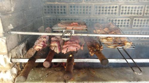 a grill with a bunch of meat and sausages at Diversão, churrasco e piscina - Praia de Ipitanga in Salvador