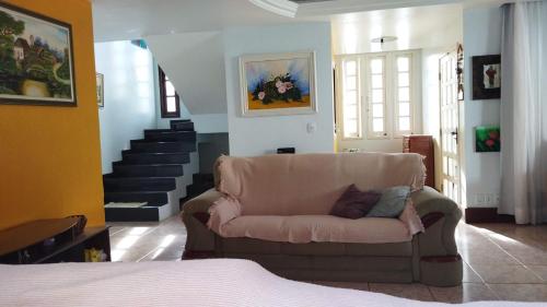 a living room with a couch and a staircase at Diversão, churrasco e piscina - Praia de Ipitanga in Salvador