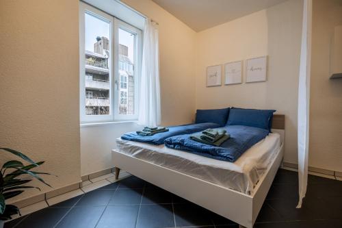 uma cama com lençóis azuis num quarto com uma janela em Gemütliches Studio im Stadtzentrum em Biel