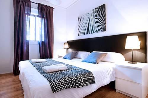 a bedroom with a large white bed and a window at Po Colorful and bright apartment in Barcelona