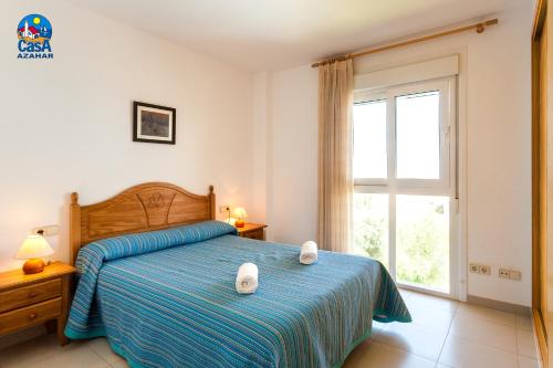 a bedroom with a bed with two white towels on it at Apartamentos Bovalar Casa Azahar in Alcossebre