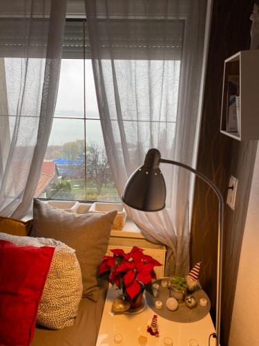 a lamp on a table in front of a window at Villa Borostyán in Tihany