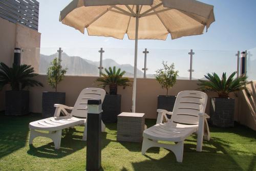 a group of chairs and an umbrella on a patio at Baity Boutique Hotel in Aqaba